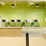 Breakroom with green walls and a line of microwaves